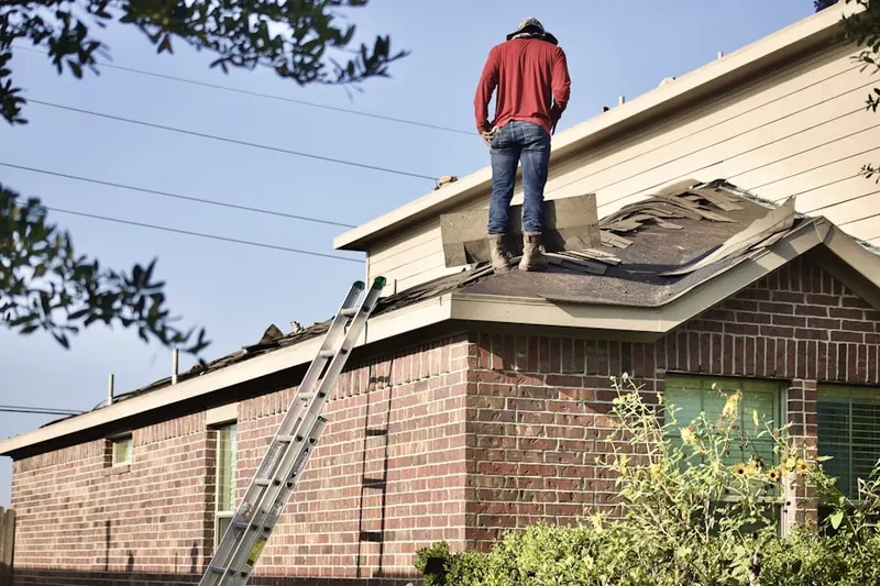 Professional roofer working on a residential roof in Westland Homesites